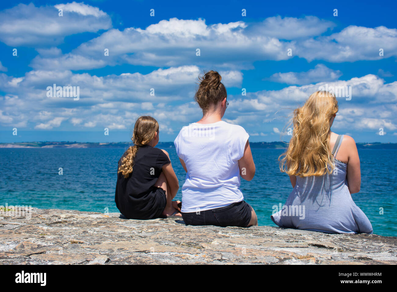 Trois filles photographiés par derrière pendant qu'ils sont à la recherche de l'océan à Camaret-sur-Mer en France Banque D'Images