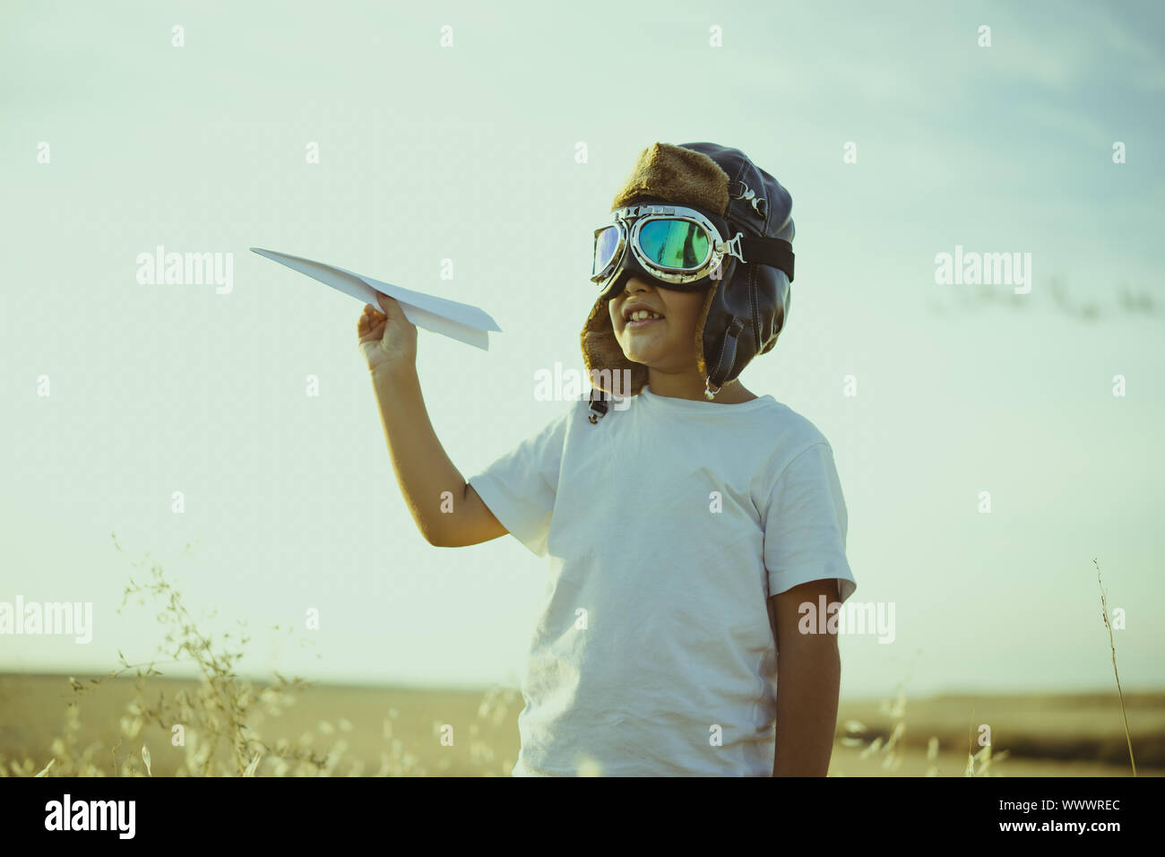 Jeu, Garçon jouant à être pilote d'avion, mec drôle avec casquette et des  lunettes aviator, porte dans sa main un avion en papier Photo Stock - Alamy