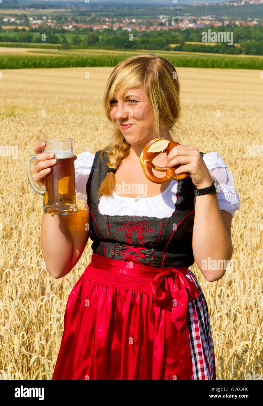 Jeune fille dans un Dirndl traditionnel de la consommation de bière dans la nature Banque D'Images