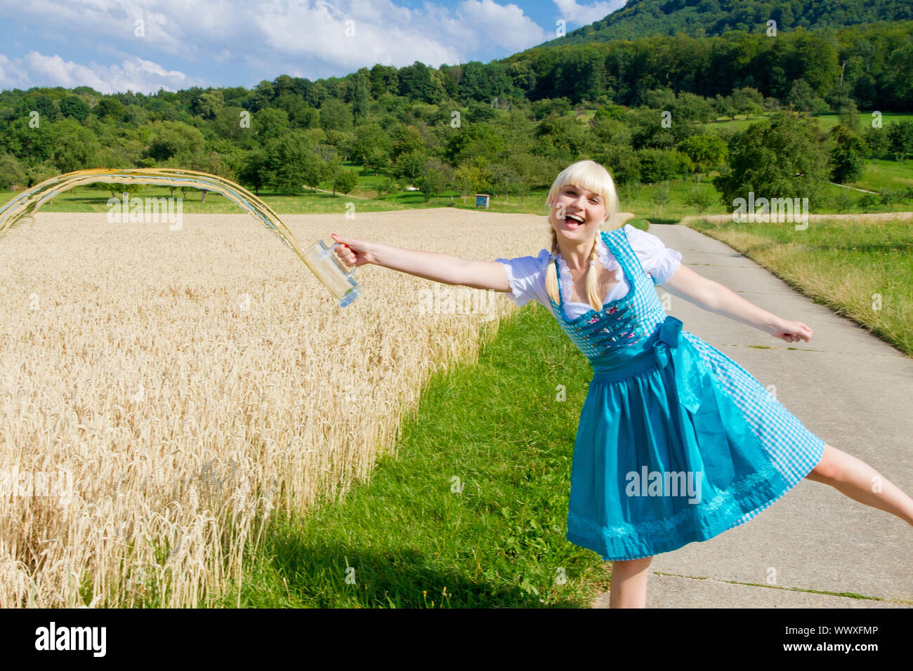 Photo d'une jeune femme dans un dirndl pour loin de la bière dans un champ Banque D'Images