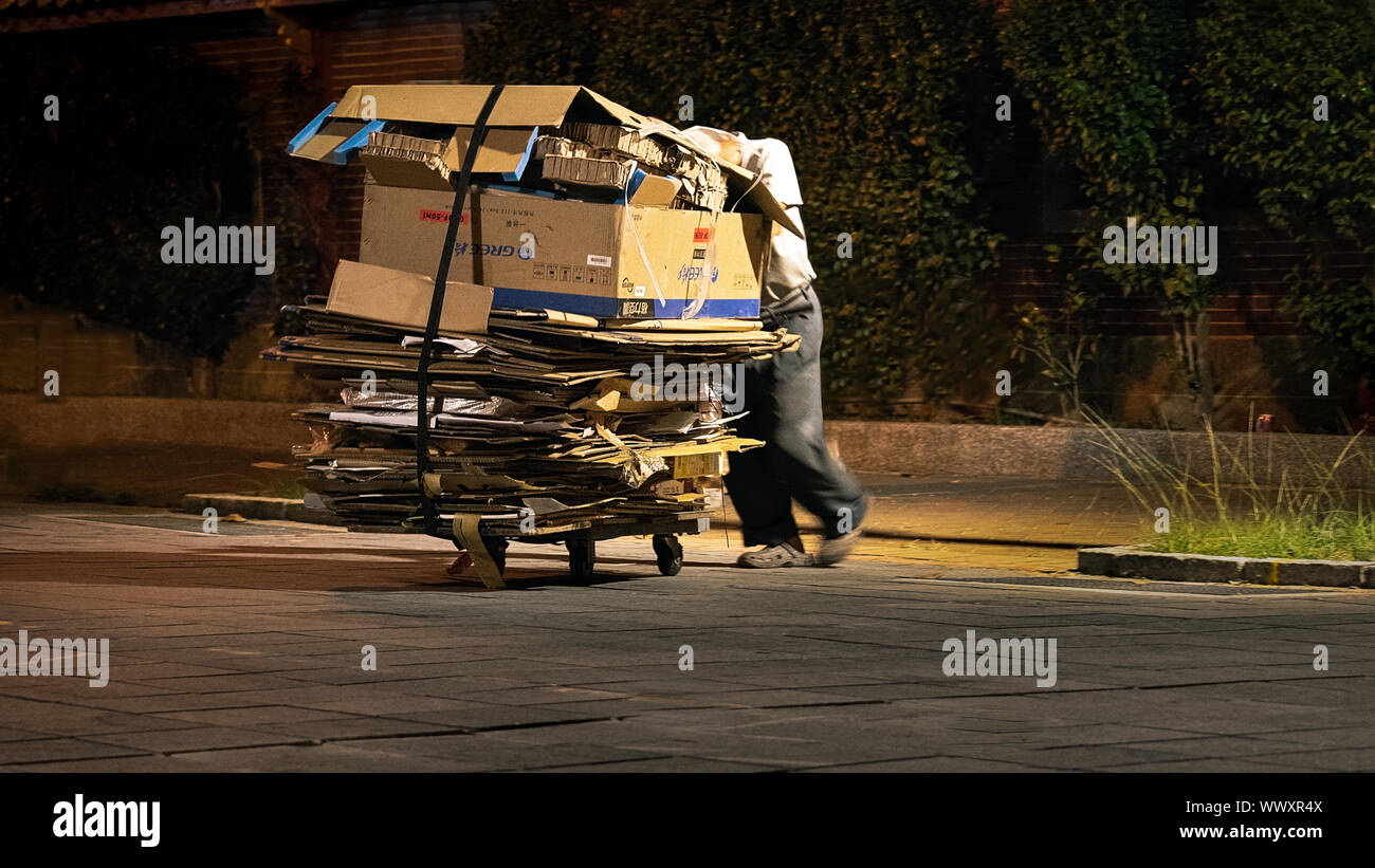 Taipei / Taiwan - le 10 août 2018 : Vieil homme poussant un chariot de carton à Taiwan dans la nuit Banque D'Images