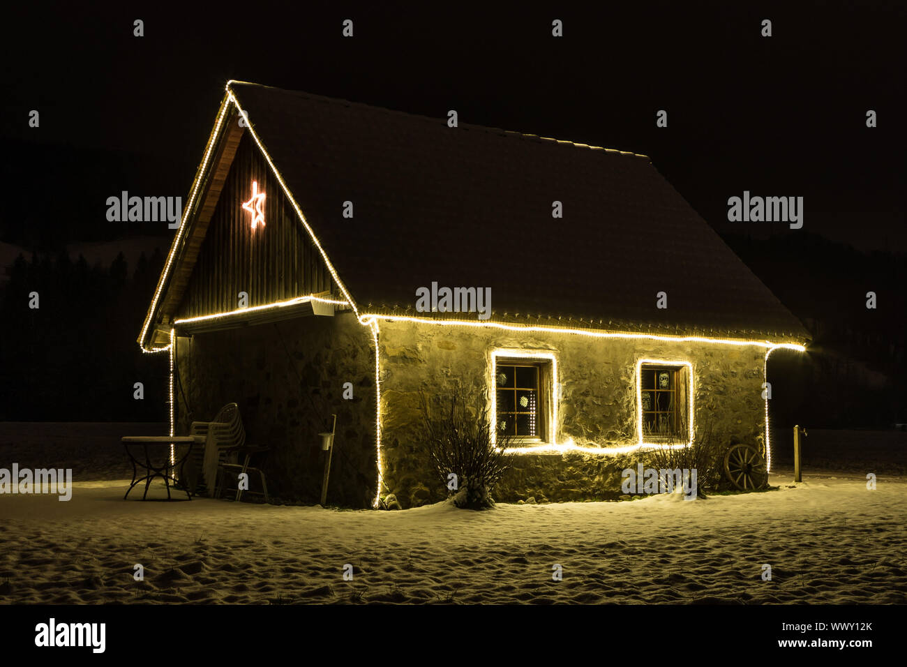 Petite maison avec fairy lights dans la nuit et la neige, de Malters, Lucerne, Suisse, les saisons Banque D'Images