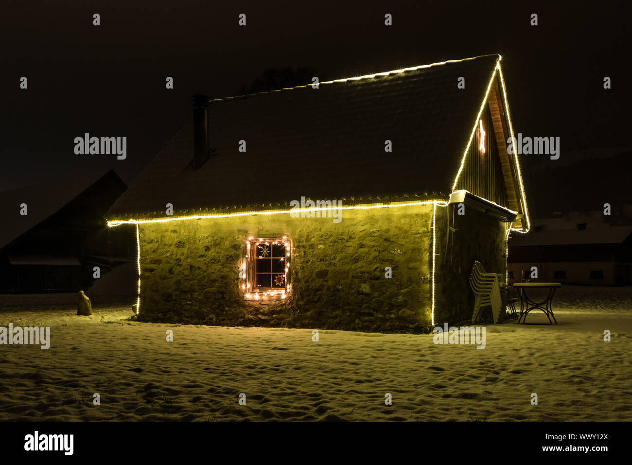 Petite maison avec fairy lights dans la nuit et la neige, de Malters, Lucerne, Suisse, les saisons Banque D'Images