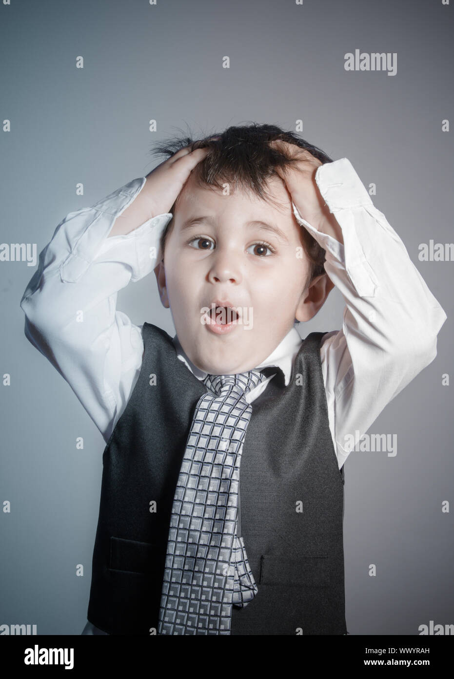 La perte d'argent, d'affaires, petit garçon brun habillé en costume et cravate avec des visages et des expressions drôles Banque D'Images