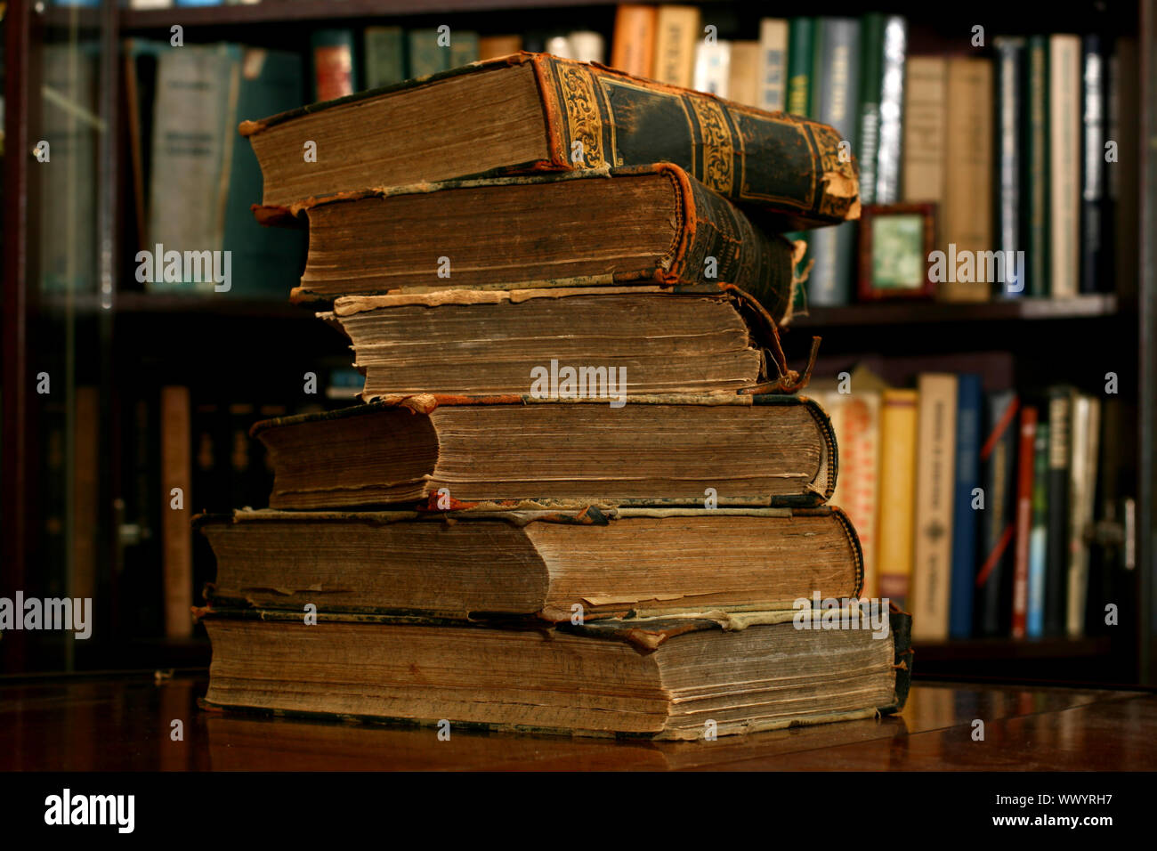 Livres sur table dans une bibliothèque sombre Photo Stock - Alamy