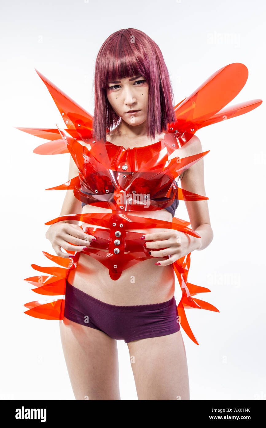 Asian woman cosplayeuse avec costume futuriste en rouge, faite de pvc et plastiques transparents. orientale Banque D'Images