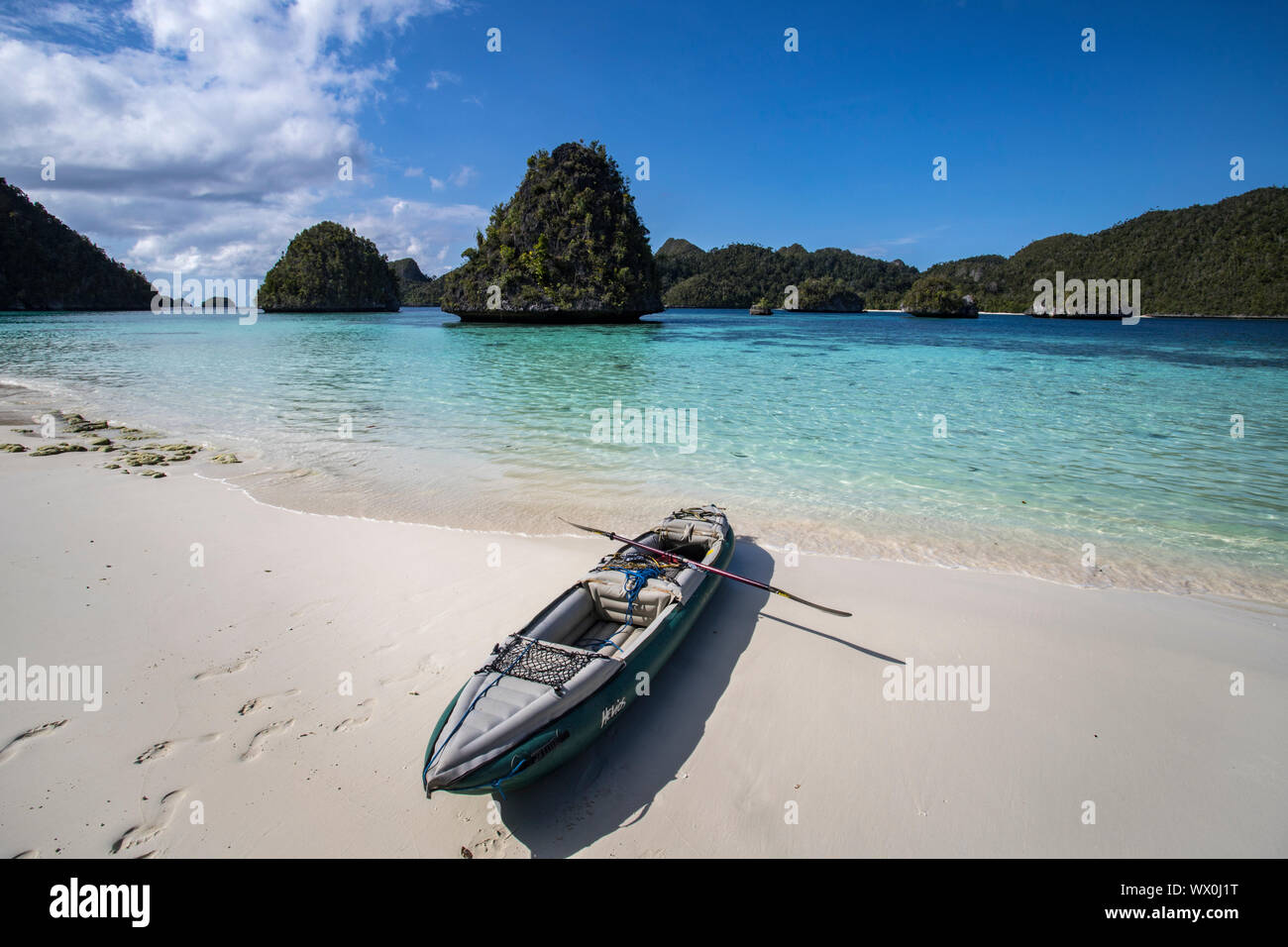 Formations calcaires karstiques et lagoon en Wayag Island avec le kayak du photographe, Raja Ampat, Papouasie occidentale, en Indonésie, en Asie du Sud-Est, l'Asie Banque D'Images