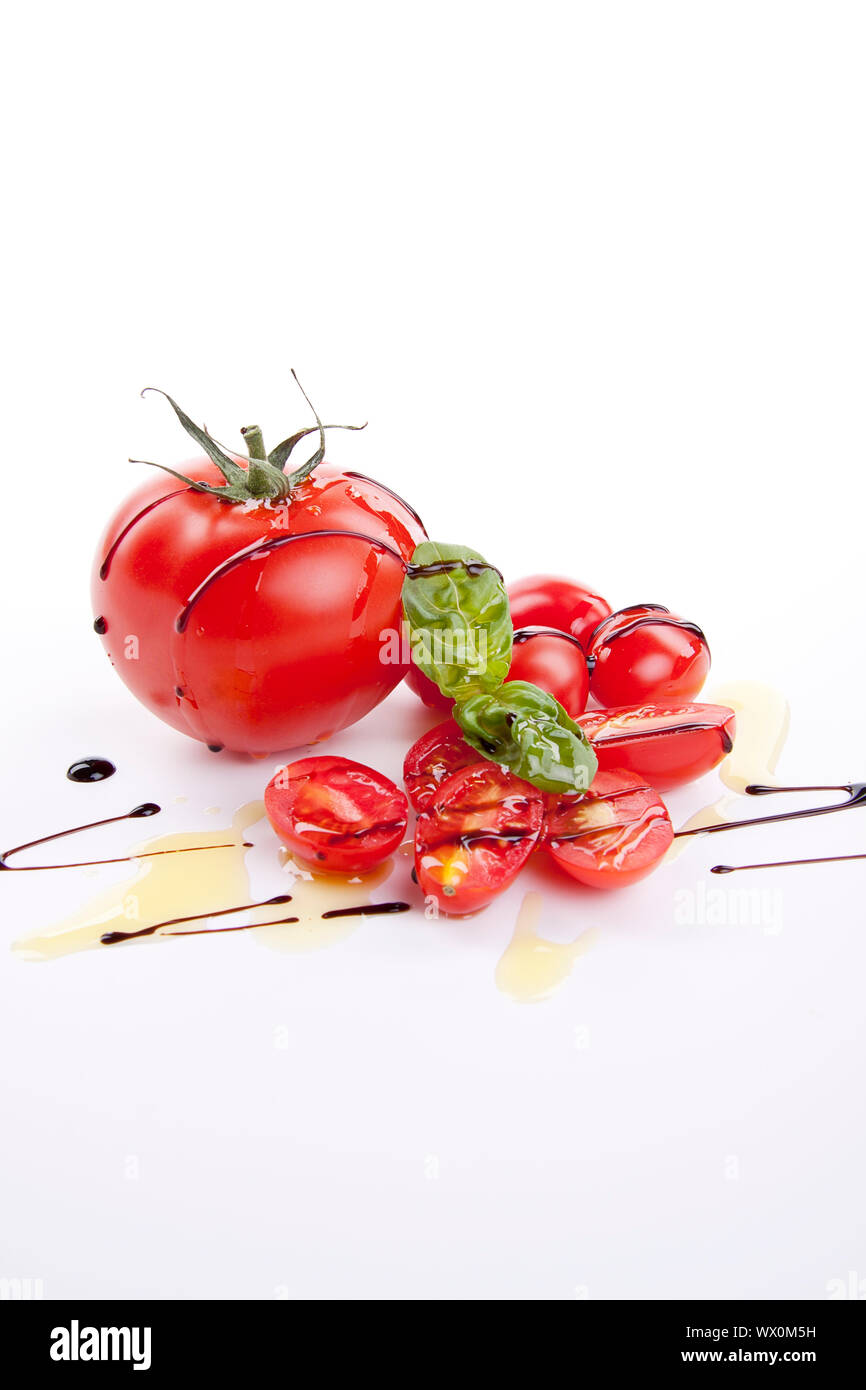 Les tomates rouges frais avec huile d'olive et balsamique isolated Banque D'Images