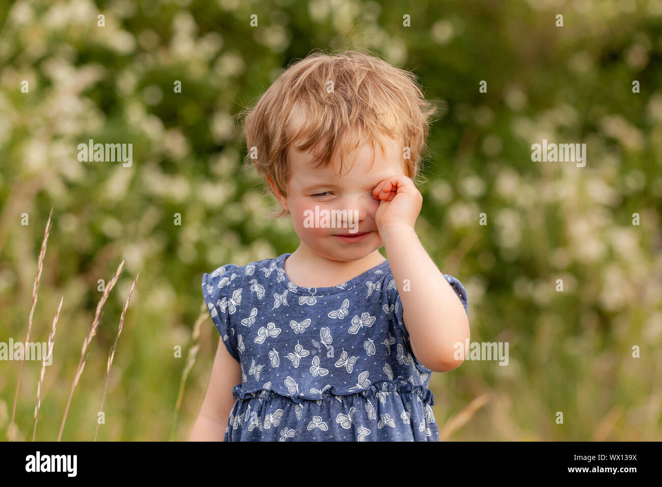 L'enfant frotte ses yeux fatigués Banque D'Images