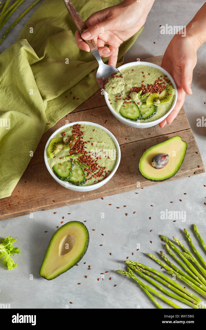 Dessert vegan aux asperges, concombre, avocat et flexseeds dans les mains d'une femme sur un fond en pierre Banque D'Images