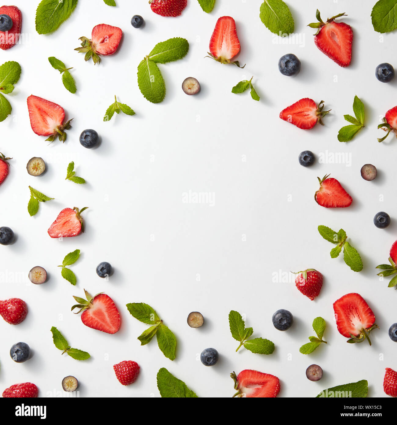 Modèle des fruits de châssis avec les fraises, les bleuets et les feuilles de menthe sur un fond blanc, télévision lay Banque D'Images