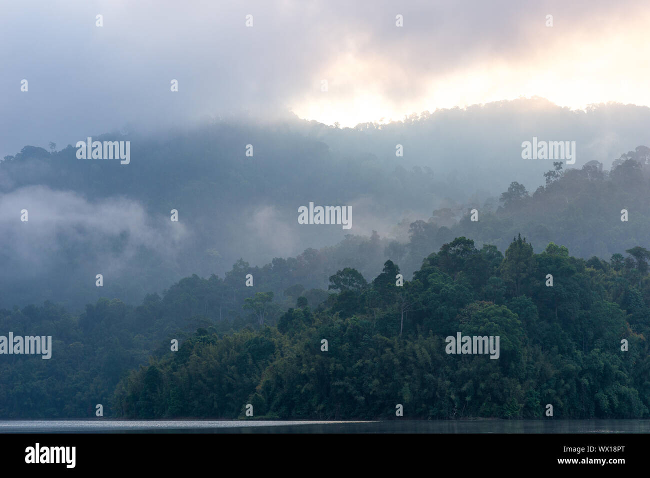 Montagnes brumeuses tôt le matin sur le lac Cheow Lan dans le parc national de Khao Sok, Thaïlande Banque D'Images