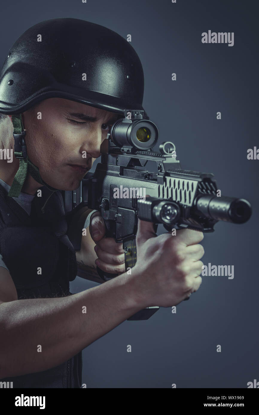 Sport paintball dvd le port de casque de protection visant pistolet ,armure noire et machine gun Banque D'Images