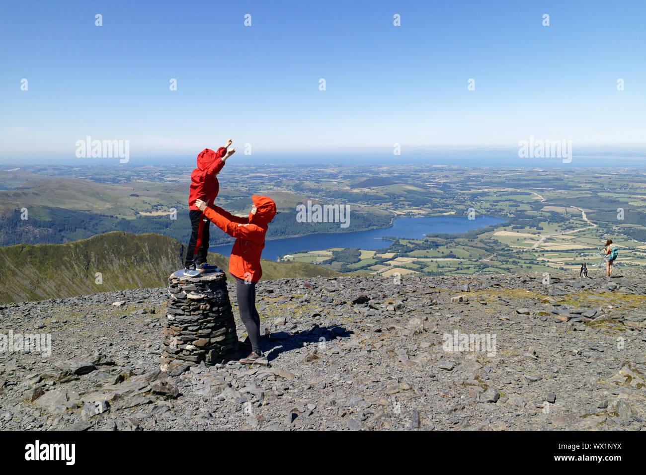 Une mère et son fils à célébrer leur arrivée sur le sommet du Skiddaw dans le Lake District, Cumbria, Royaume-Uni Banque D'Images