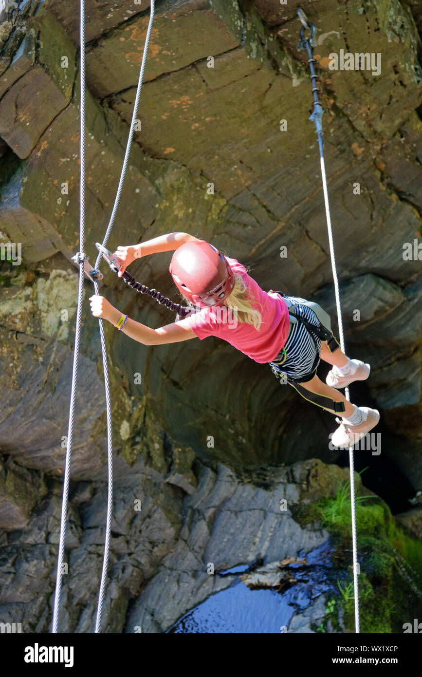 Une jeune fille sur une corde raide entre l'cliifs sur le Canyon via ferrata Sainte Anne, Québec, Canada Banque D'Images