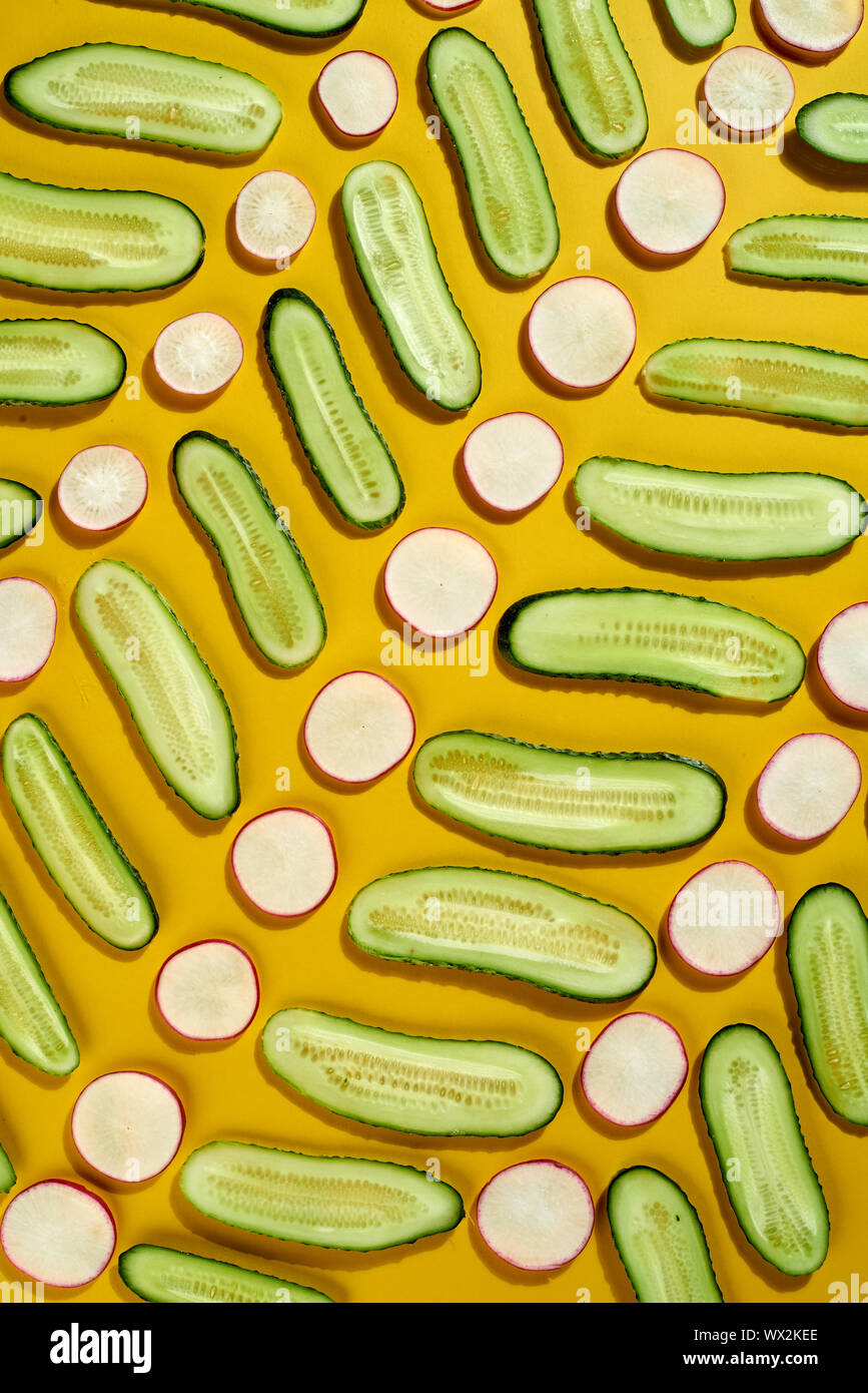 Modèle de légumes frais de création - le printemps des légumes de saison et de concombre radis pour manger sain sur un fond jaune. Banque D'Images Modèle de légumes frais de création - le printemps des légumes de saison et de concombre radis pour manger sain sur un fond jaune. Banque D'Images