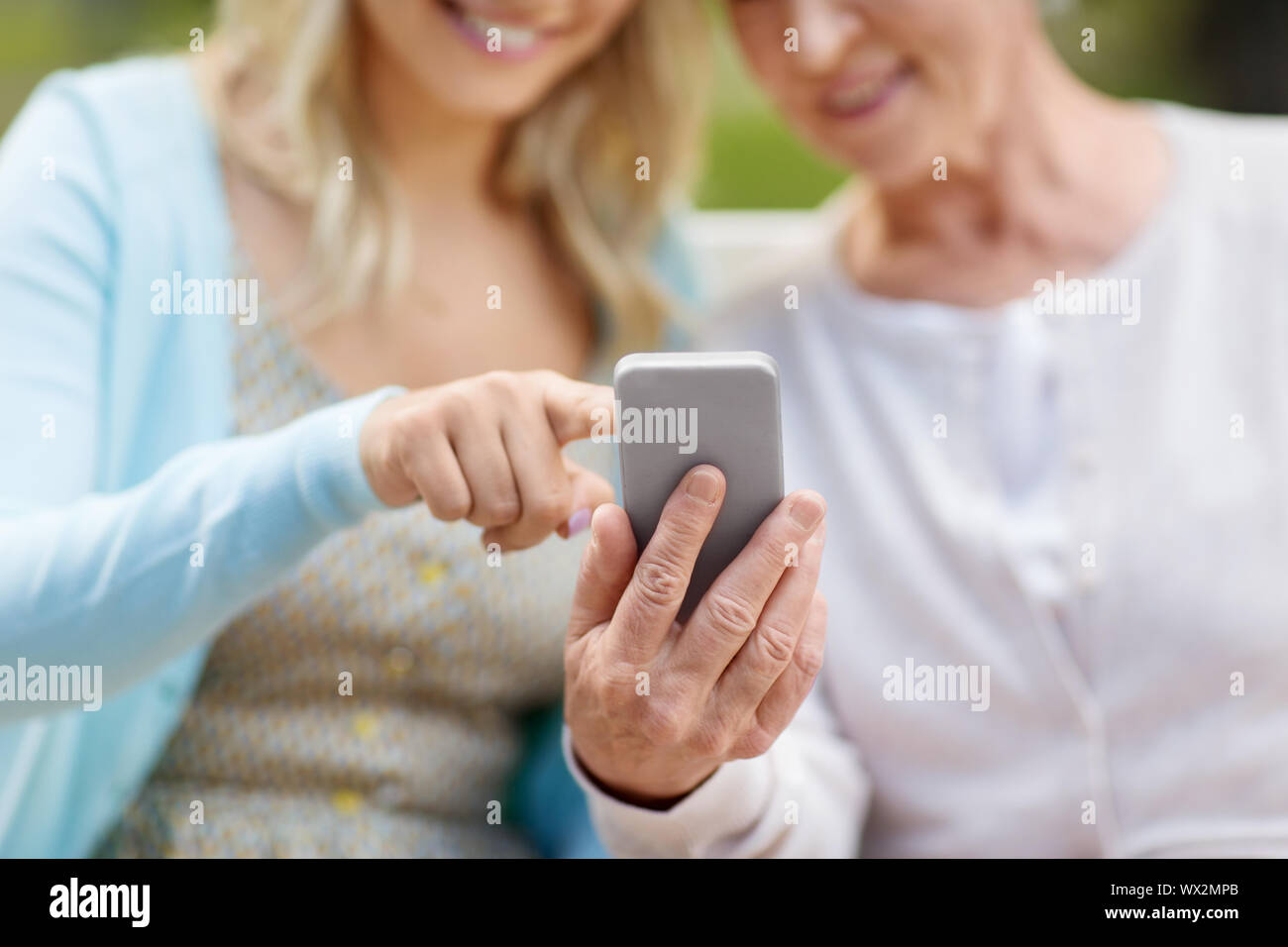 Fille et mère senior avec smartphone at park Banque D'Images