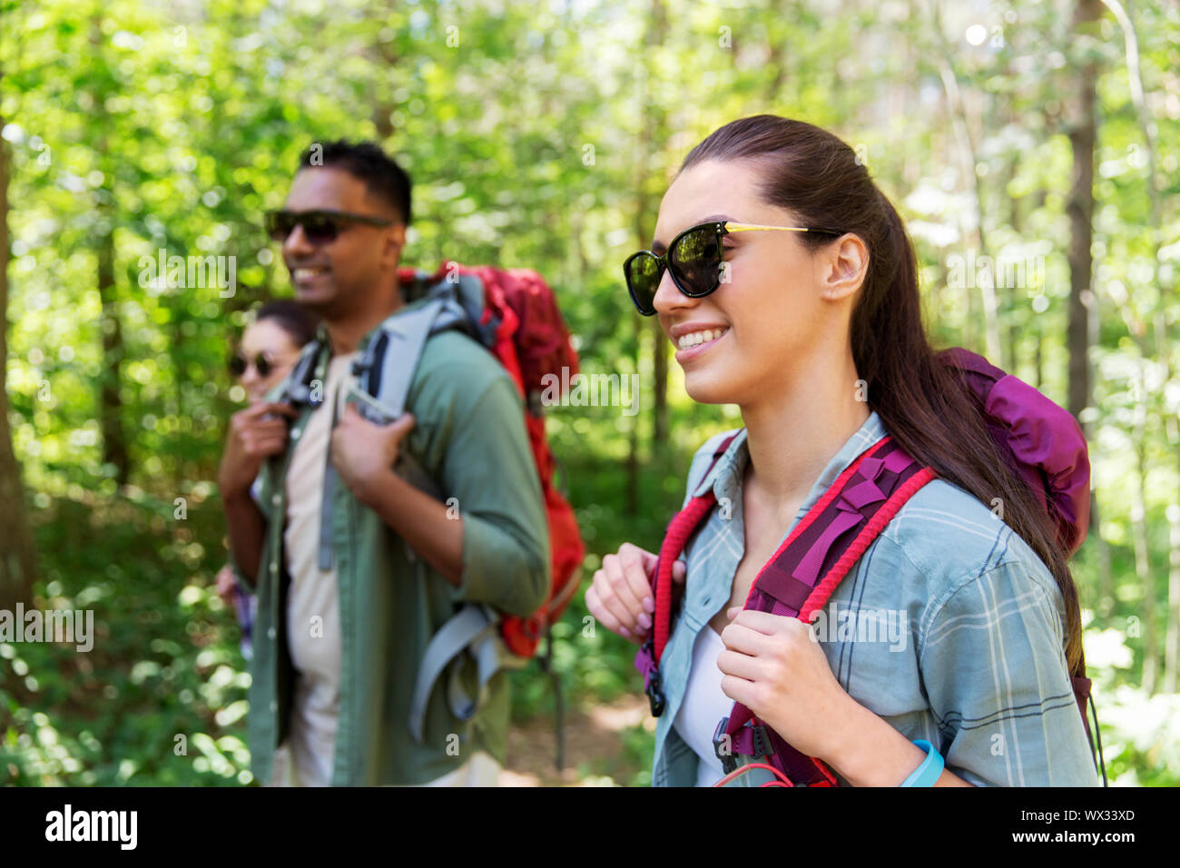 Groupe d'amis avec des sacs à dos randonnée en forêt Banque D'Images