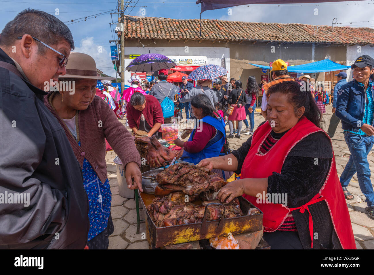 Femme vendant viande frite à un décrochage en plein air. Marché du Dimanche très occupé, ministère de Tarabuco en Sucre, Bolivie, Amérique Latine Banque D'Images