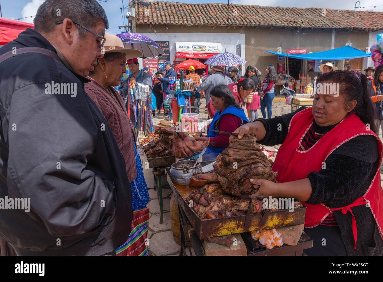 Femme vendant viande frite à un décrochage en plein air. Marché du Dimanche très occupé, ministère de Tarabuco en Sucre, Bolivie, Amérique Latine Banque D'Images