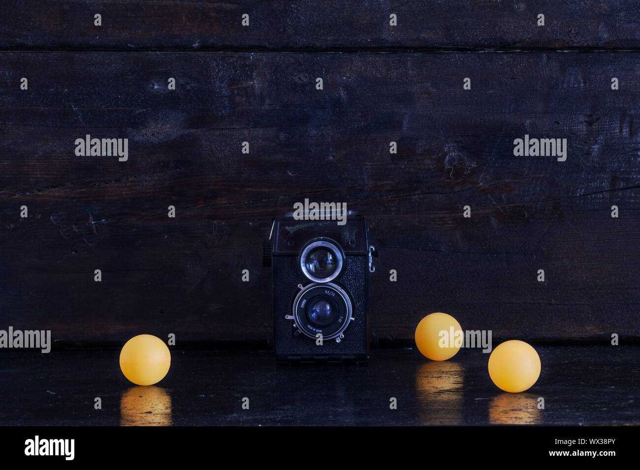 Ancien appareil photo et boules jaunes sur une sombre.retro Banque D'Images