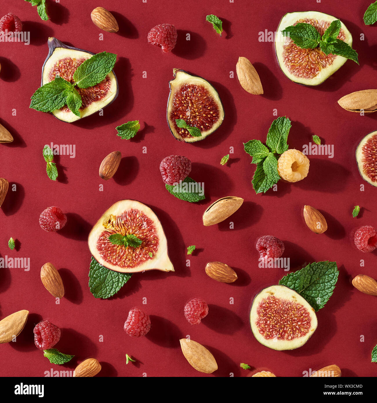Framboises bio, amandes, figues et de feuilles de menthe sur un fond rouge foncé. Mode d'alimentation. Mise à plat Banque D'Images Framboises bio, amandes, figues et de feuilles de menthe sur un fond rouge foncé. Mode d'alimentation. Mise à plat Banque D'Images