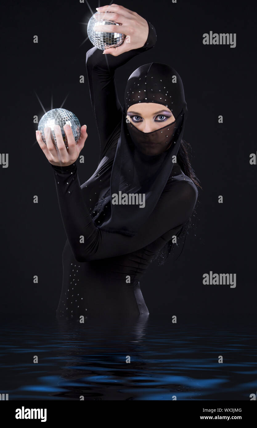 Partie danseur dans ninja dress avec boules disco Banque D'Images