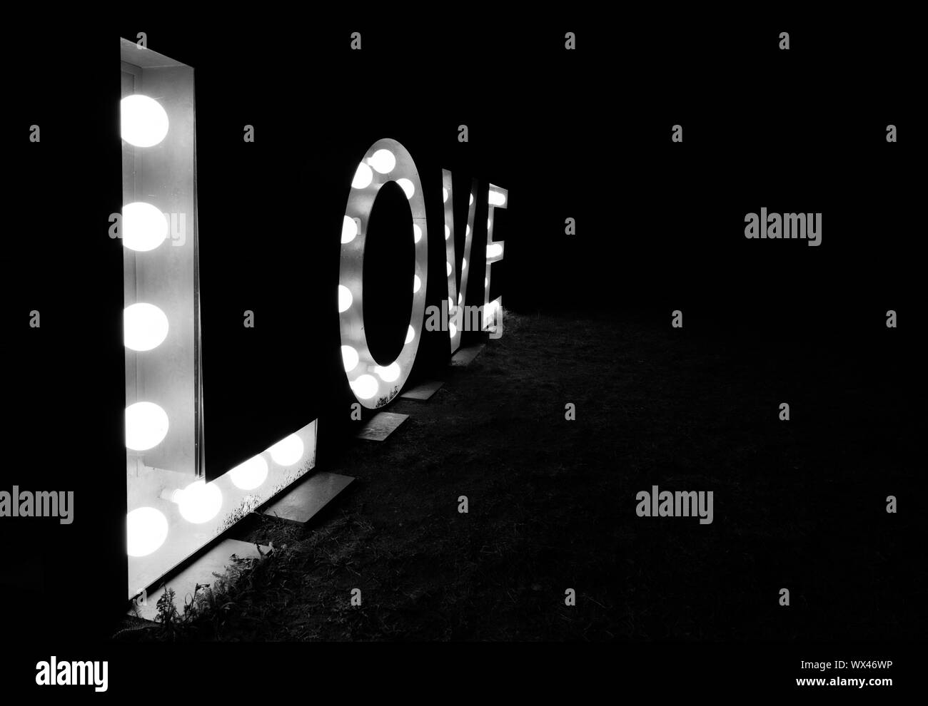 Nuit noire avec la parole et l'amour du texte écrit en lettres lumineuses en noir et blanc Banque D'Images