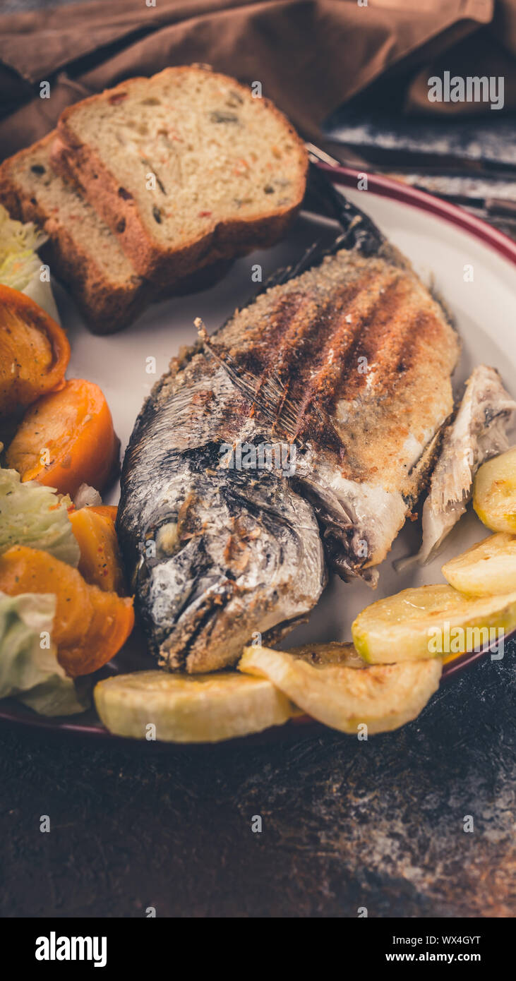 Poisson avec légumes grillés dorada close-up. Shot verticale Banque D'Images