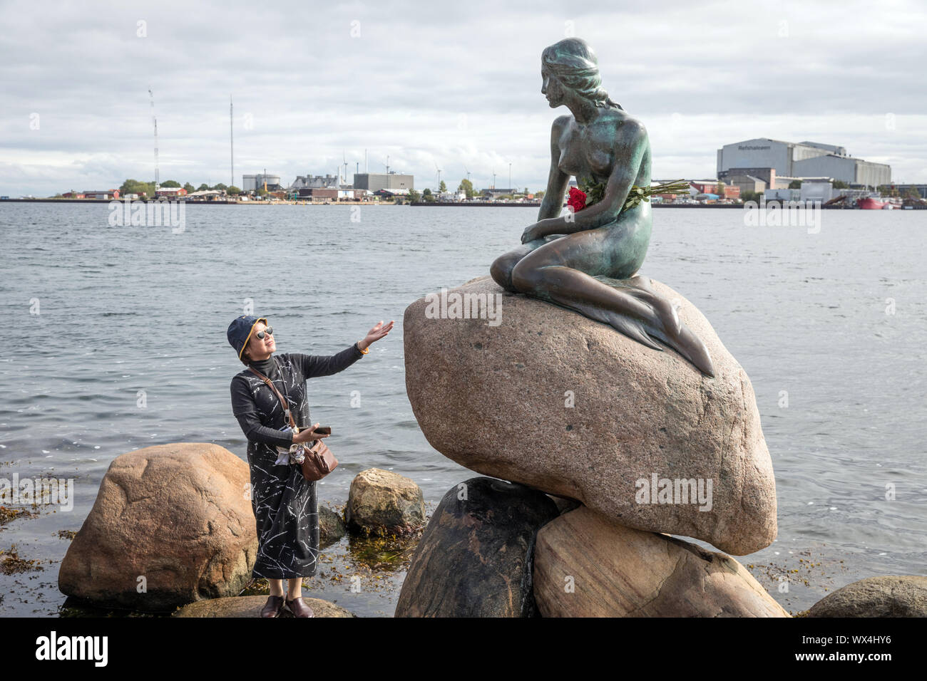 Un visiteur avec Edvard Eriksen's statue de la Petite Sirène à Langelinie, Copenhague, Danemark Banque D'Images Un visiteur avec Edvard Eriksen's statue de la Petite Sirène à Langelinie, Copenhague, Danemark Banque D'Images