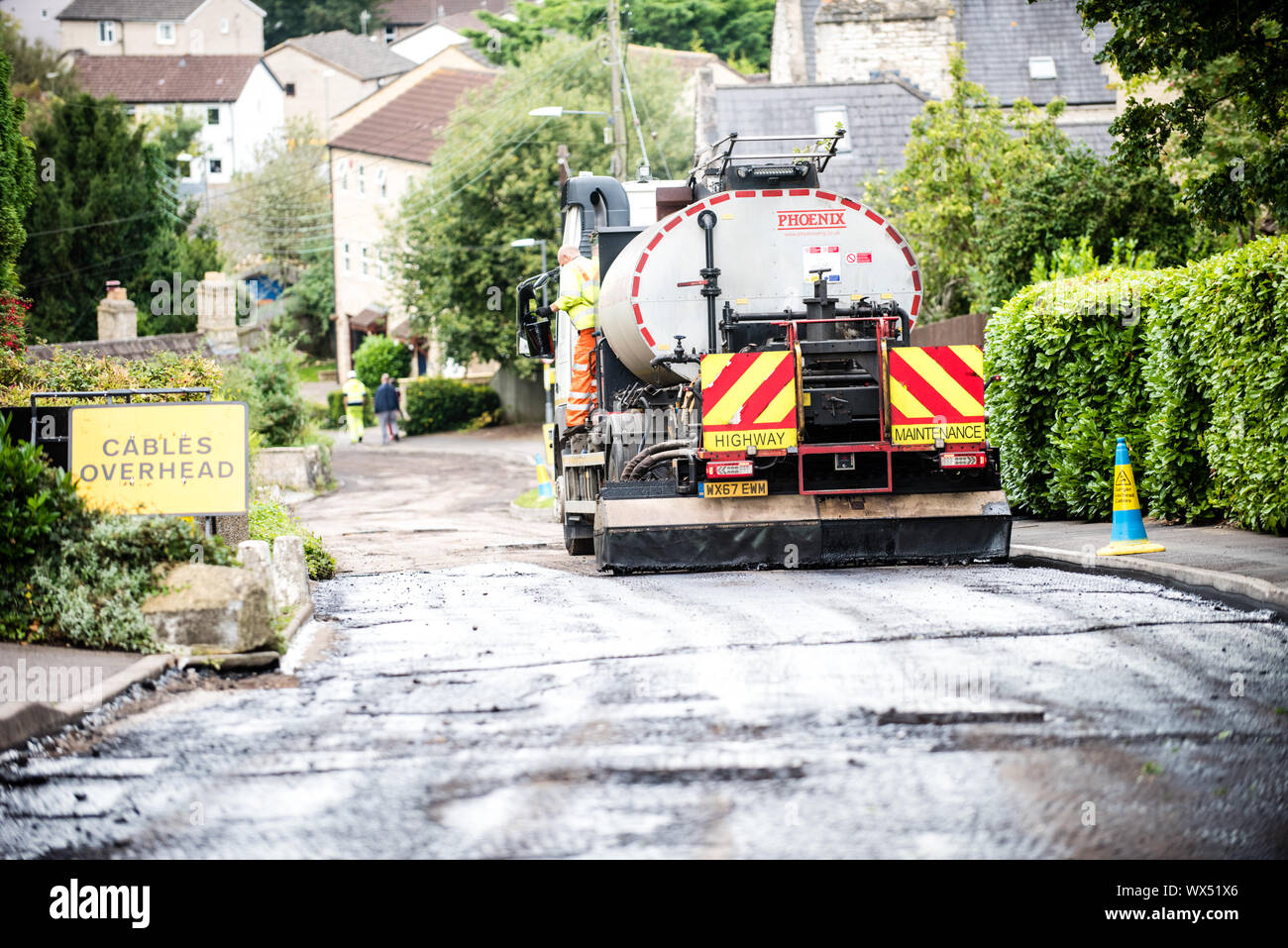 Retour d'un navire-citerne en stationnement sur une route rurale d'être refait surface dans le cadre de travaux d'entretien routier ini l'été au Royaume-Uni Banque D'Images