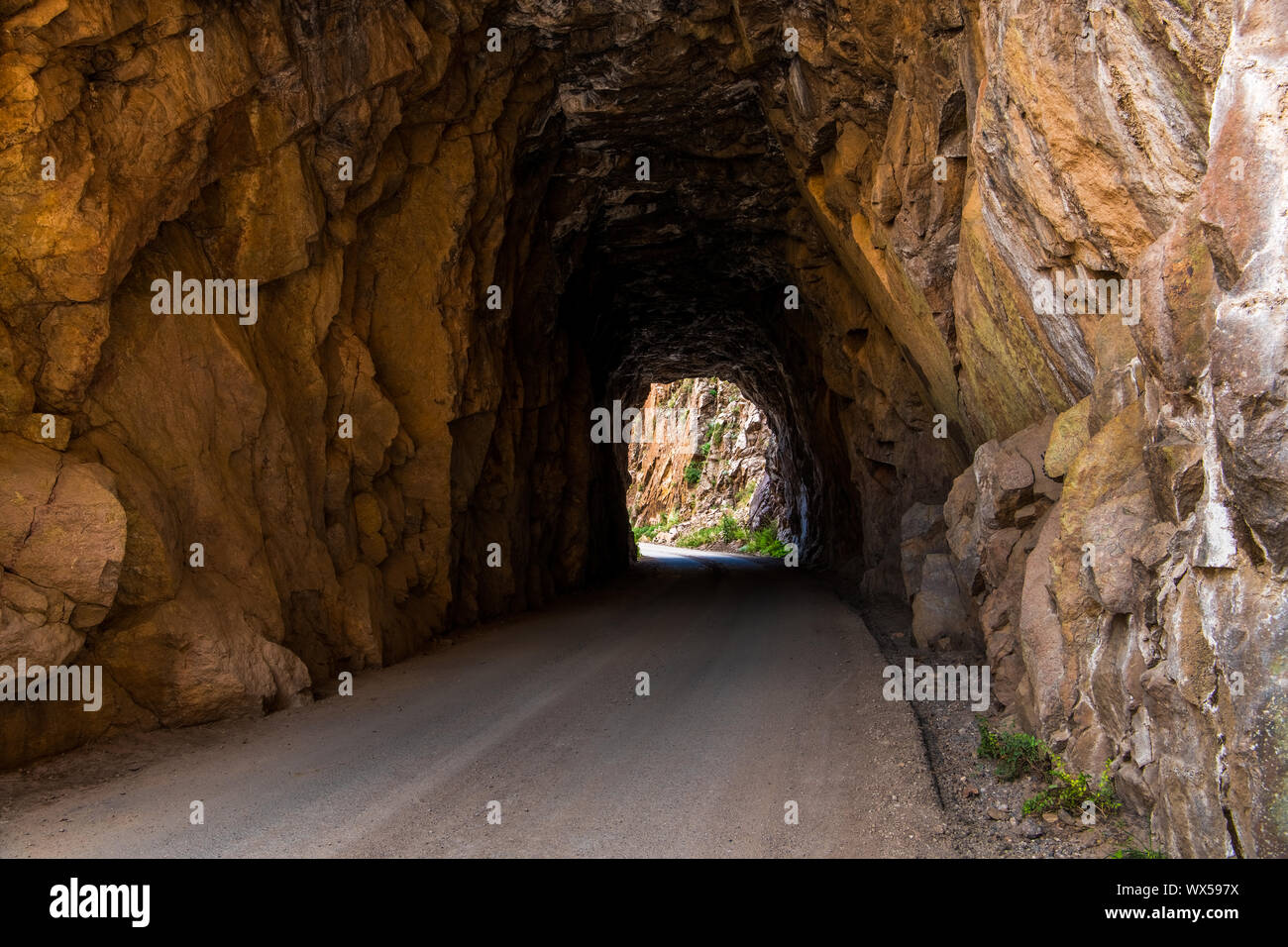Tunnel et route tournant grâce à red rock grès - Gilman tunnels près de Jemez Springs dans le nord du Nouveau Mexique Banque D'Images
