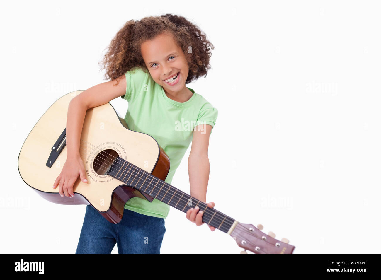 Happy girl joue de la guitare sur un fond blanc. Banque D'Images