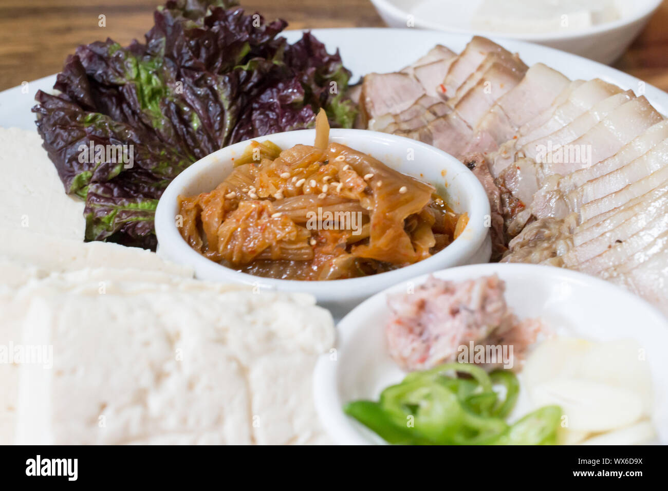 La nourriture traditionnelle coréenne, bossam porc bouilli mangé avec une sauce salée et enveloppés dans les verts, bossam kimchi Banque D'Images