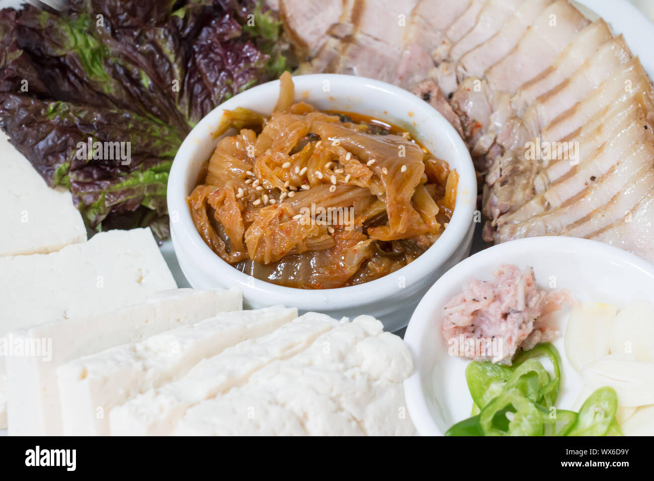 La nourriture traditionnelle coréenne, bossam porc bouilli mangé avec une sauce salée et enveloppés dans les verts, bossam kimchi Banque D'Images