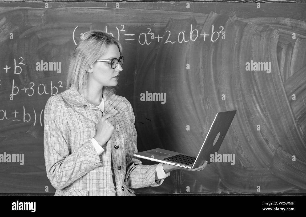 Concept de formation à distance. L'enseignant détient dame portent des lunettes pour ordinateur portable Internet surf. Femme blonde enseignant avec ordinateur portable moderne tableau internet surf arrière-plan. L'innovation de l'école. Banque D'Images