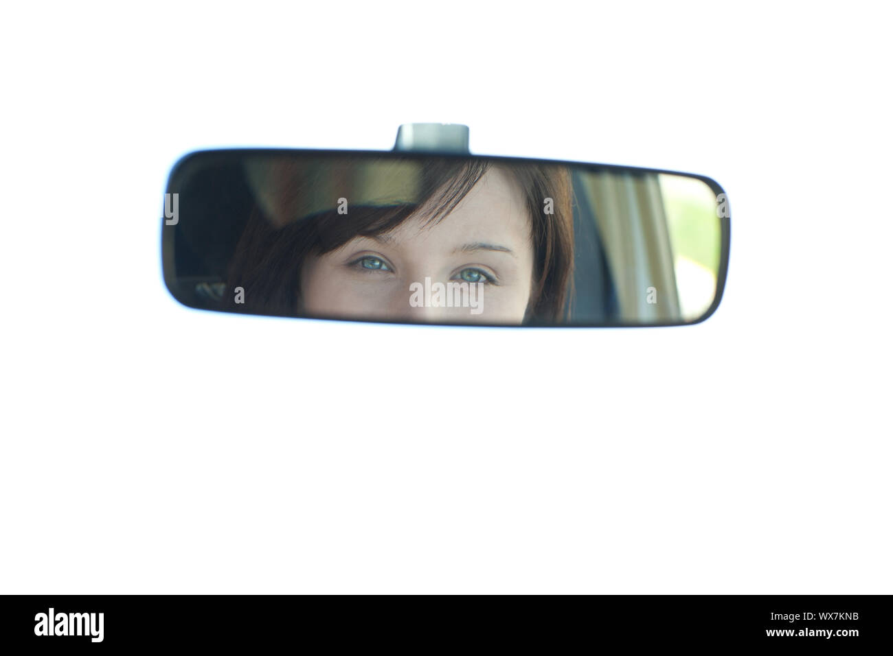 Jeune femme assise sur le siège du conducteur, et à la recherche dans le rétroviseur Banque D'Images