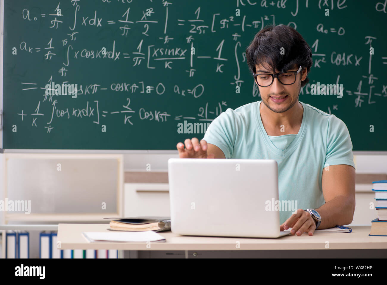 Young male student mathématicien en face de tableau Banque D'Images