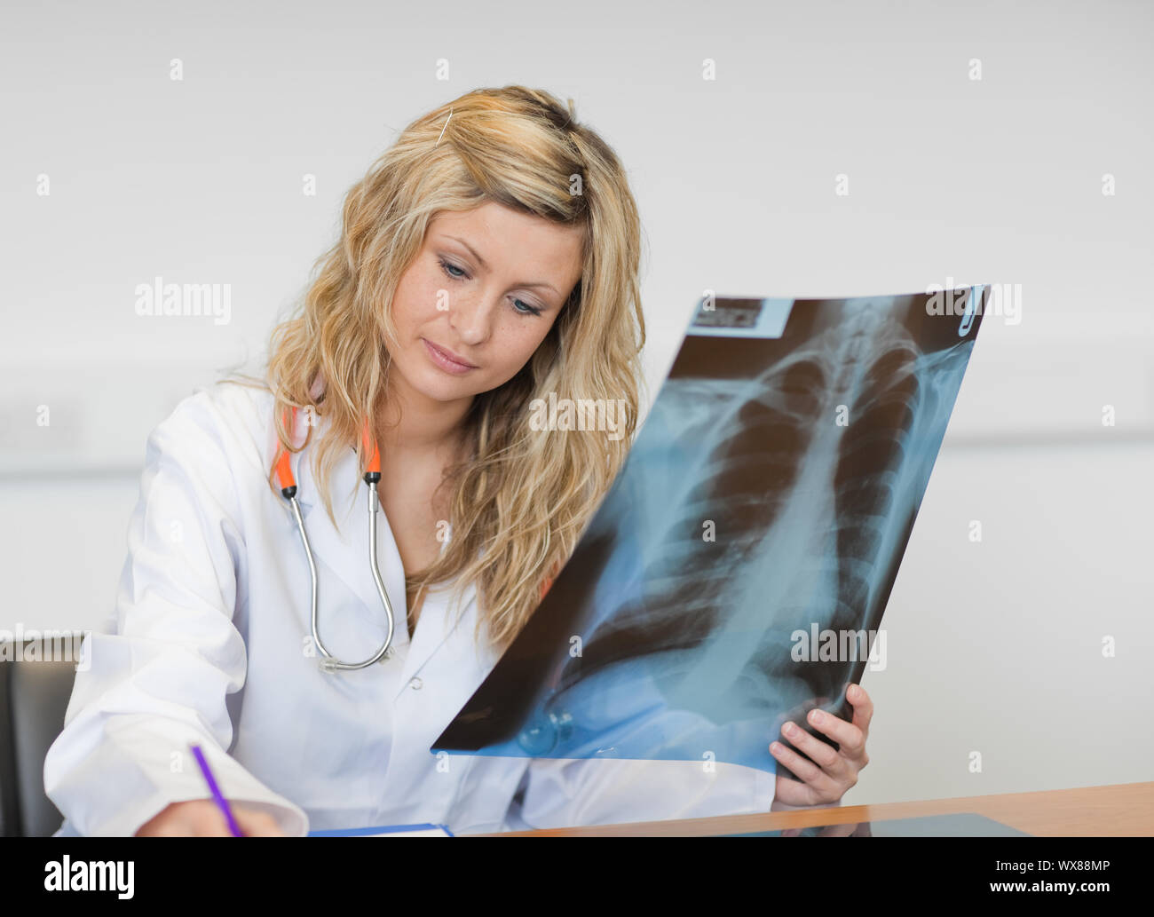 Pretty doctor holding a X-ray report Banque D'Images