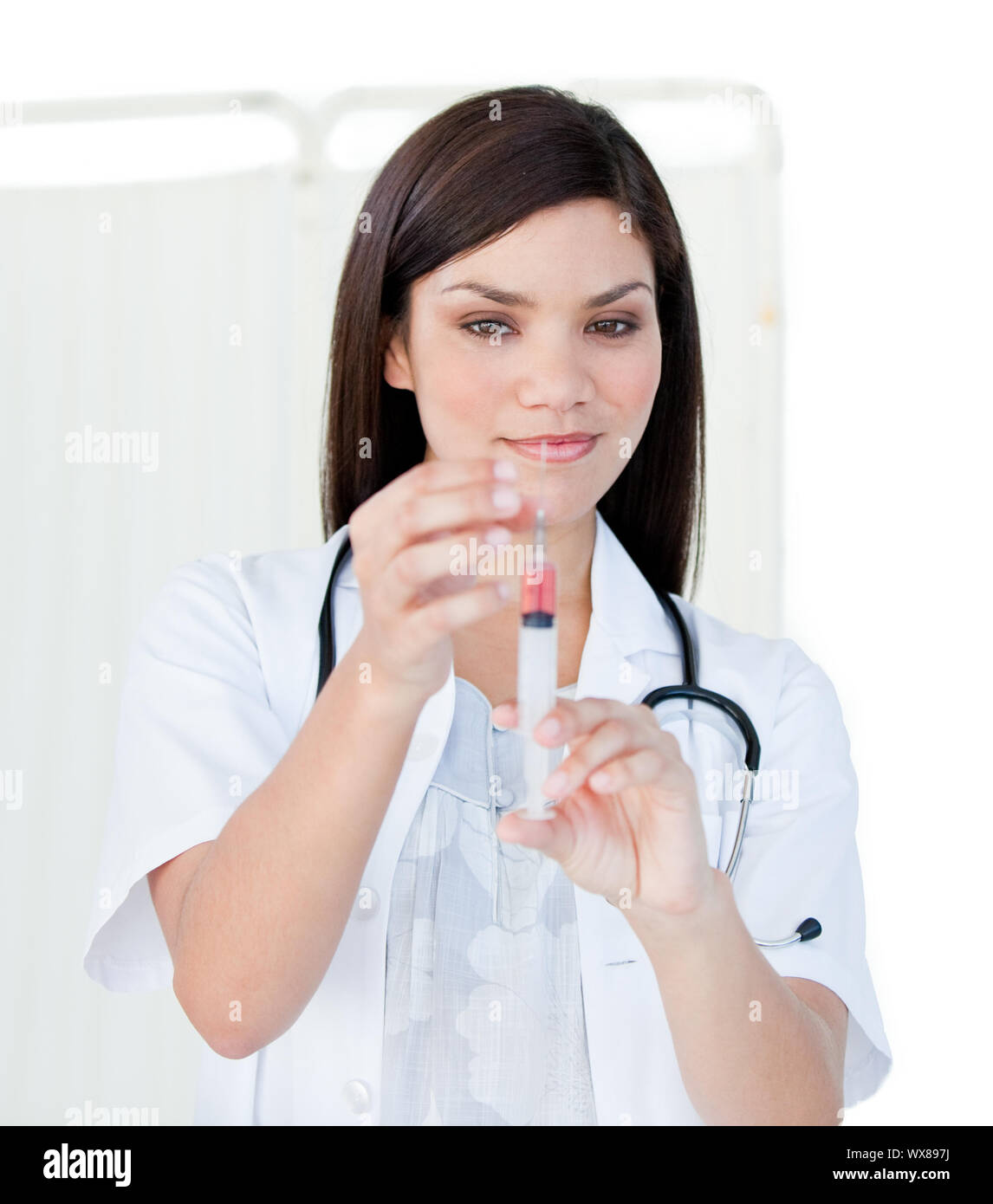 Portrait of a cute femme médecin la préparation d'une seringue dans un hôpital Banque D'Images