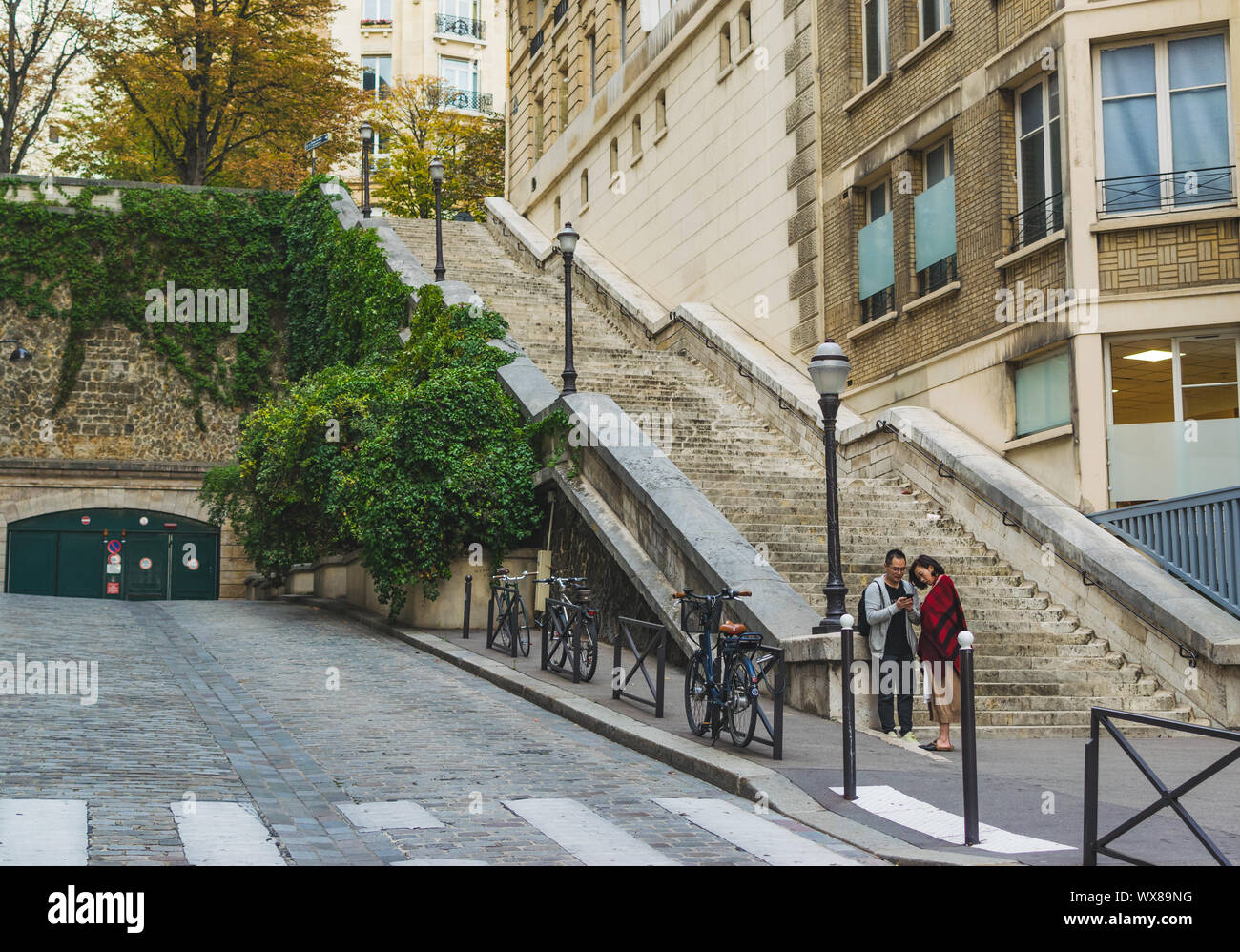 PARIS, FRANCE - 02 OCTOBRE 2018:Jeune couple préparation à la prise de photo en face d'escaliers. Banque D'Images