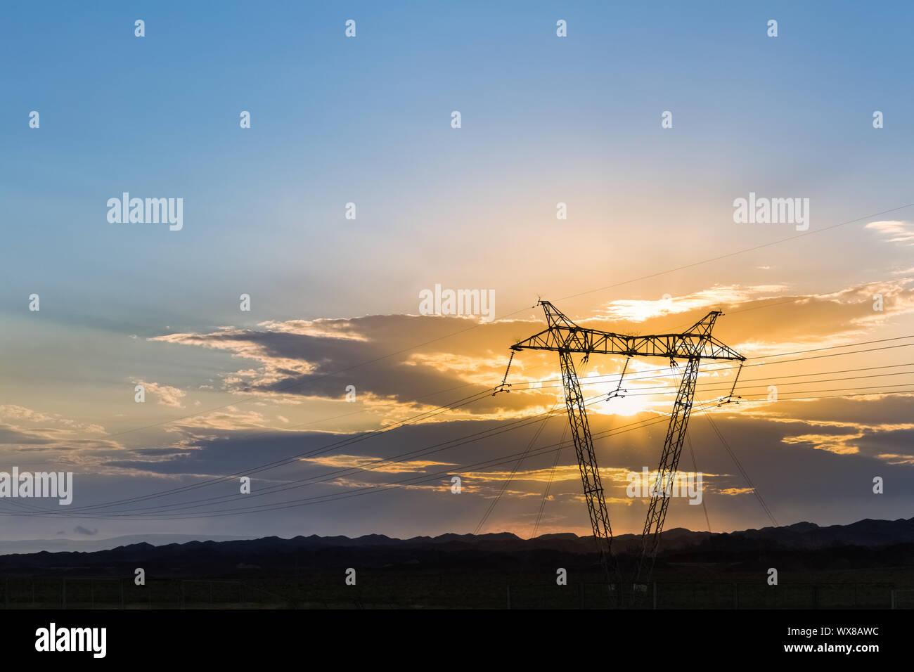 La tour de transmission de puissance dans le coucher du soleil Banque D'Images
