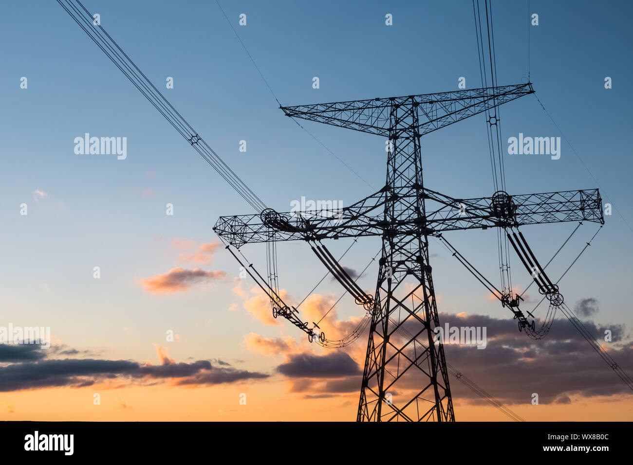 La tour de transmission de puissance avec coucher du soleil glow Banque D'Images