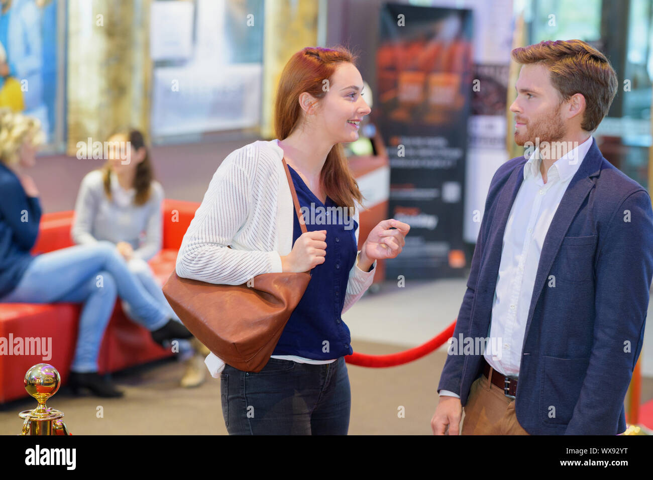 Couple en conversation sur le cinéma hall Banque D'Images