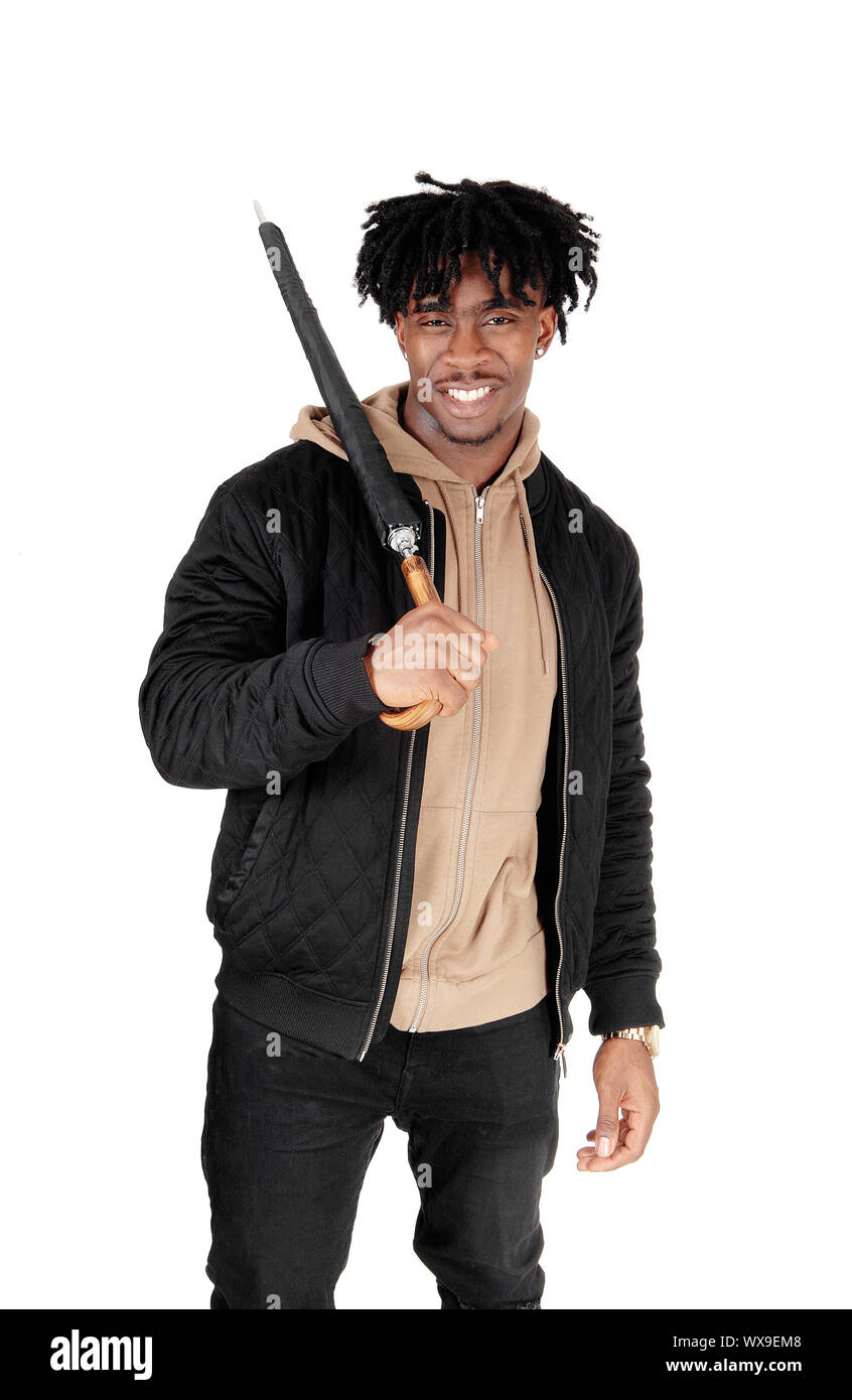 Homme Noir debout dans le studio avec parasol au-dessus de l'épaule Banque D'Images