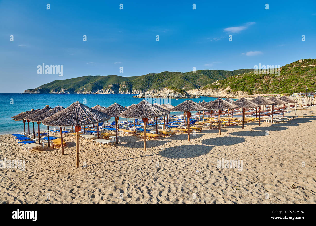 Plage avec chaises longues et parasols en Grèce Banque D'Images