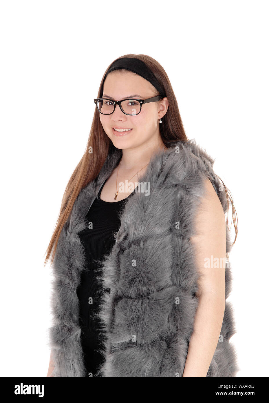 Young smiling girl debout dans sa veste en fourrure avec des lunettes Banque D'Images