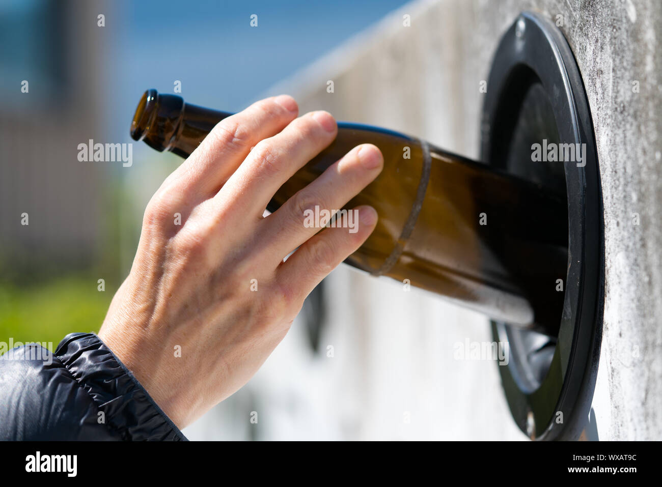 Femme respectueuse de l'environnement utilise les installations de la ville de recycler le verre Banque D'Images