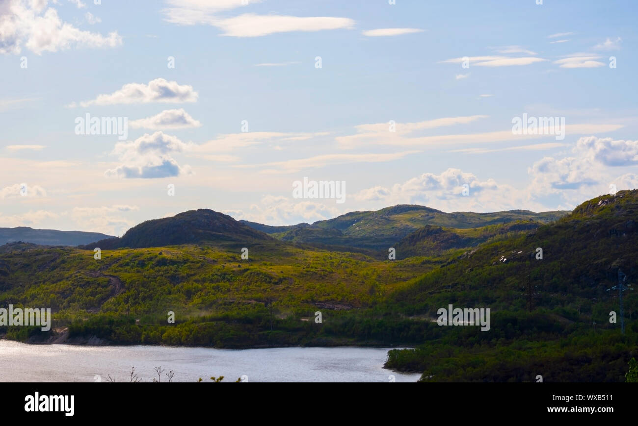 De vertes collines sous un ciel du Nord, profonde et paisible lac. Ces lieux, dans la région de Mourmansk ne sont pas loin de Teriberka. Les nuages volent au-dessus de l'tre Banque D'Images