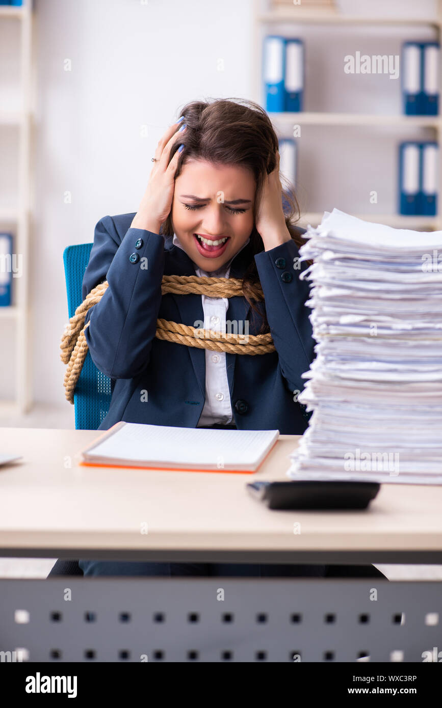 Belle jeune employé attaché avec une corde dans le bureau Banque D'Images